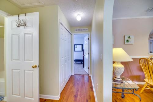 a hallway with a white door and a table with a lamp at 15 Mi to Melbourne Beach Peaceful Palm Bay Escape in Palm Bay