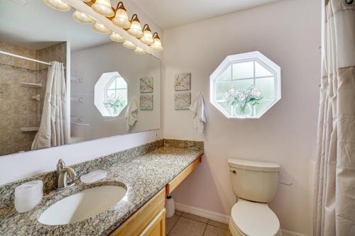 a bathroom with a sink and a toilet and a mirror at 15 Mi to Melbourne Beach Peaceful Palm Bay Escape in Palm Bay