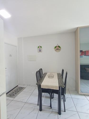 a dining room with a table and chairs at Confortável Apto de 2 Quartos - Lagoa Quente in Caldas Novas