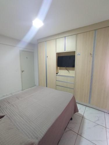 a bedroom with a bed and a flat screen tv at Confortável Apto de 2 Quartos - Lagoa Quente in Caldas Novas
