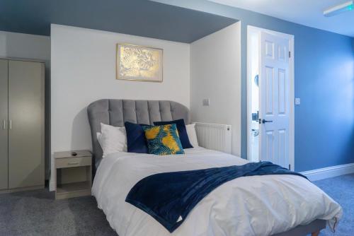 a bedroom with a large bed with blue walls at Carlisle Aglionby Escape in Carlisle