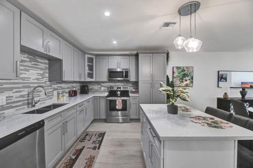 eine Küche mit weißen Schränken und einer Spüle und einem Herd in der Unterkunft Beachside Villa in Fort Lauderdale