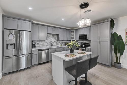 eine Küche mit Geräten aus Edelstahl und einer weißen Insel in der Unterkunft Beachside Villa in Fort Lauderdale