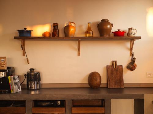 a shelf with vases and other items on it at La Maison du Marché in Saint-Pierre