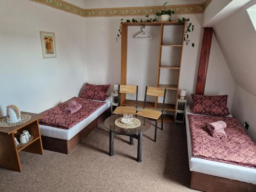 a small room with two beds and a table at penzion U losa in Spořice