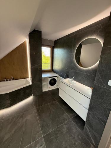 a bathroom with a sink and a mirror at Kika House in Pasym