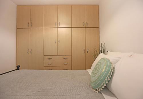 a bedroom with wooden cabinets and a bed with a pillow at Terra Olivae Syros in Ermoupoli