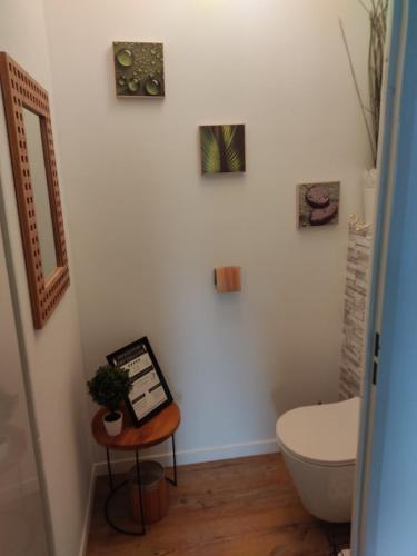- une salle de bains avec toilettes et un panneau sur une table dans l'établissement Appart 2 chambres à Anglet, à BIQ