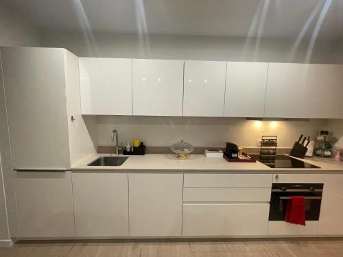 a white kitchen with white cabinets and a sink at OneLuxStay near Antwerp Central in Antwerp