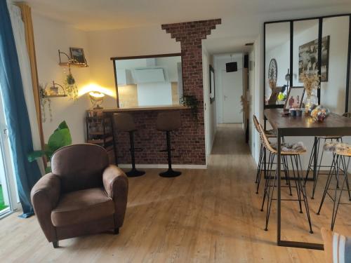 un salon avec une chaise et une table dans l'établissement Appart 2 chambres à Anglet, à BIQ