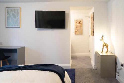 a bedroom with a bed and a tv on a wall at Carlisle Aglionby Escape in Carlisle