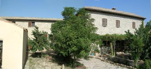 an old building with a tree in front of it at Sa Domu de sa Contissa in Sèlegas