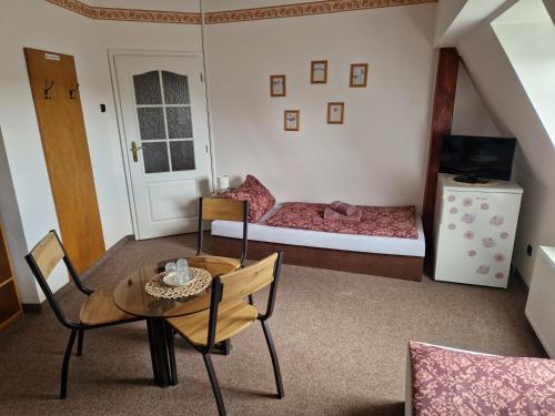 a small room with a table and a bed at penzion U losa in Spořice