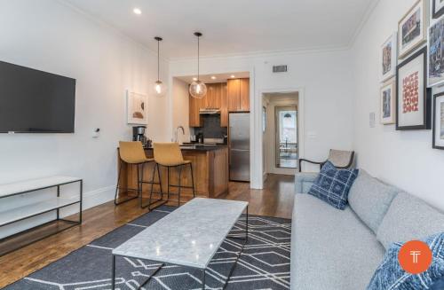 a living room with a couch and a kitchen at 304 Newbury Street by Thatch in Boston