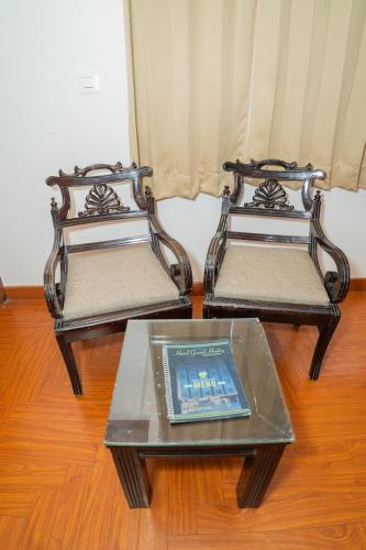 two metal chairs with a table with a tablet on it at Grand Hridey 1 minute from Railway Station in Amritsar