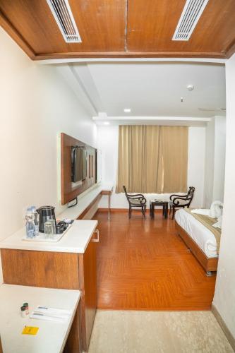 a living room with a bed and a couch at Grand Hridey 1 minute from Railway Station in Amritsar
