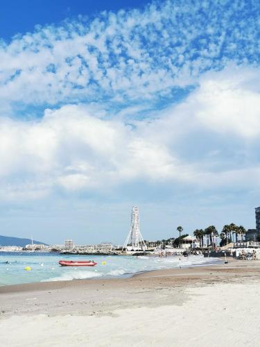a view of a beach with a ferris wheel in the background at Charmant 2 pièces proche centre ville et mer in Saint-Raphaël
