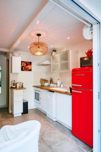 a kitchen with a red refrigerator and a sink at Charmant 2 pièces proche centre ville et mer in Saint-Raphaël