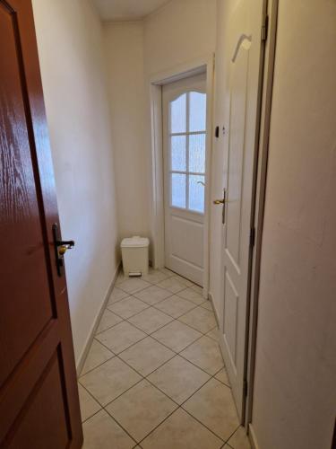 a hallway with a door and a tiled floor at penzion U losa in Spořice
