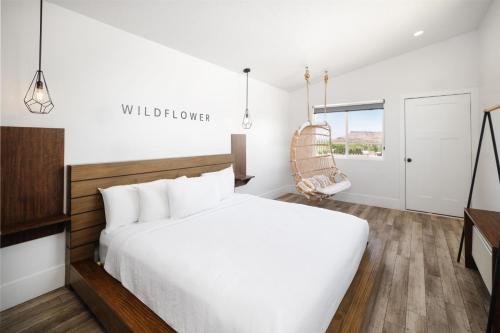 a bedroom with a white bed and a chair at Zion Wildflower Resort in Virgin