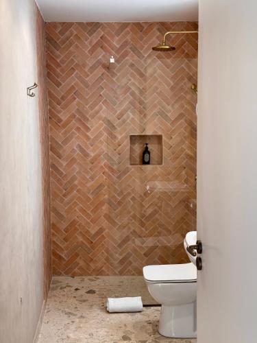 a bathroom with a toilet and a brick wall at Liberty House - Central Two Bedroom Apartments in Nicosia
