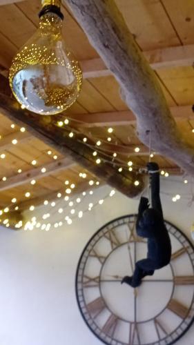 a large clock hanging from a ceiling with lights at Mas d'Andiol in Plan-dʼOrgon
