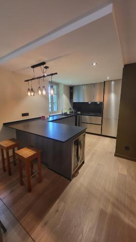 - une grande cuisine avec une grande île dans l'établissement Le Rustique, à Thonon-les-Bains