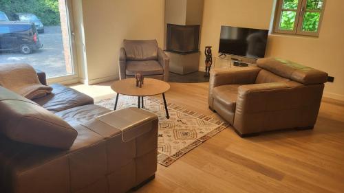 un soggiorno con un divano, sedie e un tavolo di Le Rustique a Thonon-les-Bains