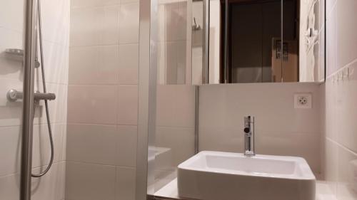 une salle de bain blanche avec un lavabo et une douche dans l'établissement Résidence Plein Sud - Plan Peisey - Studio 4 personnes à Plan Peisey proche des commerces et des pistes MAE-1964, à Peisey-Nancroix