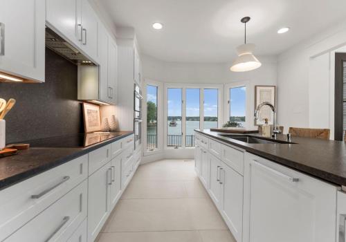 a kitchen with white cabinets and black countertops at Stone Point Overlook in Mooresville