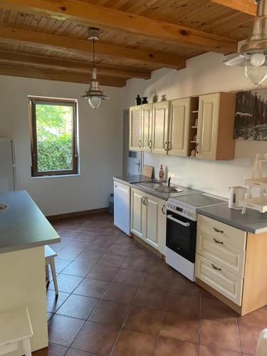 Una cocina con gabinetes blancos y un horno de estufa. en Dom letniskowy Kasia Rowy, en Rowy