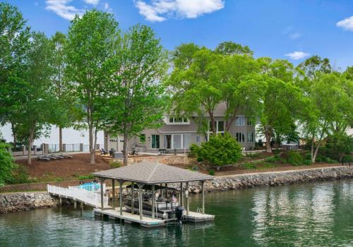 a dock on a river with a house in the background at Stone Point Overlook in Mooresville