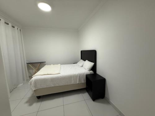 a bed in a room with a white wall at 268 Self-catering Apartments in Swakopmund