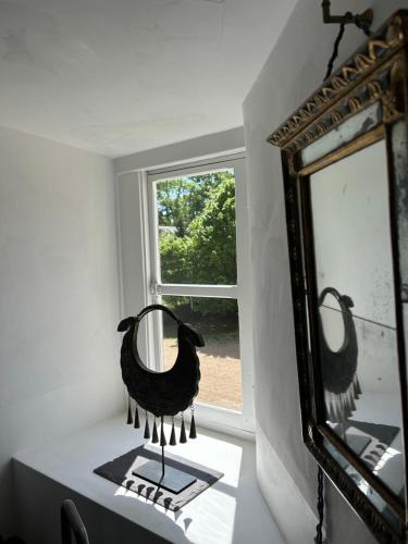 a mirror sitting on a table next to a window at Château de La Tour en Brenne in Rivarennes