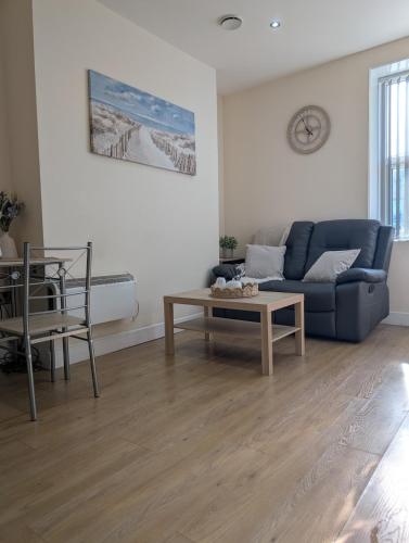a living room with a blue couch and a table at Apartment in West Yorkshire in Huddersfield