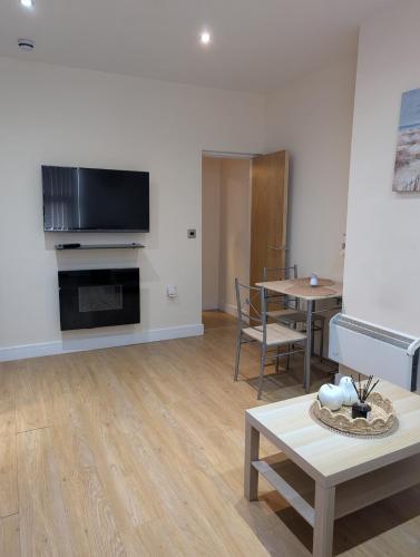 a living room with a couch and a table and a television at Apartment in West Yorkshire in Huddersfield