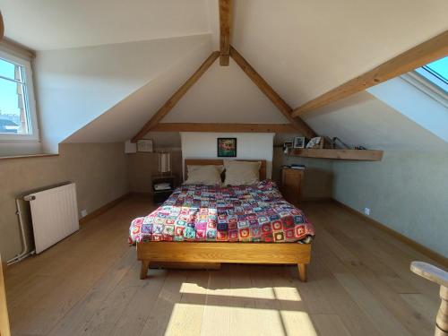 une chambre avec un lit dans un grenier dans l'établissement Maison avec Jardin Clos proche Rouen, à Sotteville-lès-Rouen