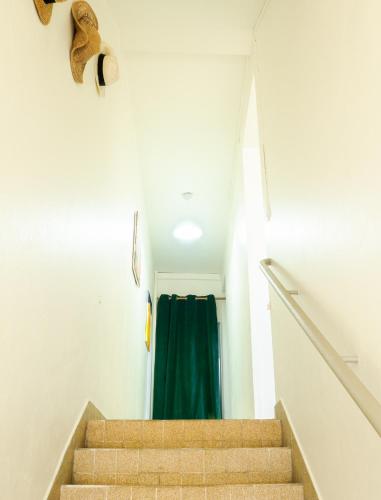 a staircase with a green shower curtain in a room at La Maison du Marché in Saint-Pierre