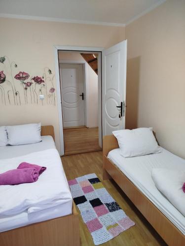 a bedroom with two beds and a mirror at Privatan smeštaj Velić in Donji Milanovac