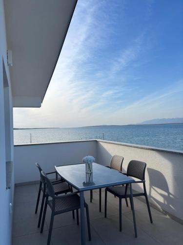 ニンにあるApartments Sabunの海が見えるバルコニーに置かれたテーブルと椅子