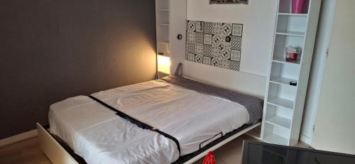 - un petit lit dans une chambre avec une étagère dans l'établissement studio la rochelle, à La Rochelle