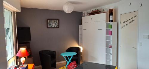 Cette chambre comprend un réfrigérateur blanc et une table. dans l'établissement studio la rochelle, à La Rochelle