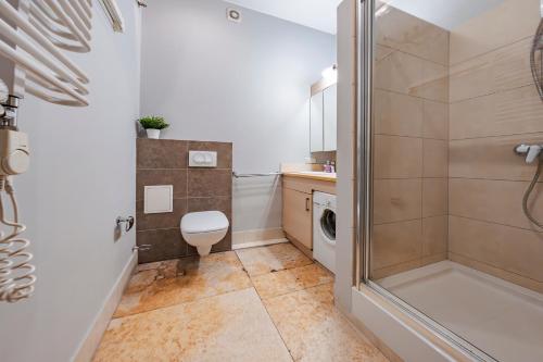 a bathroom with a shower and a toilet and a sink at Amber Apartments in Gdańsk