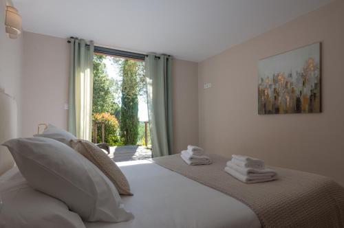 a bedroom with a bed with white pillows and a window at Appartement Stintinu - Tarra Zuria in Bonifacio