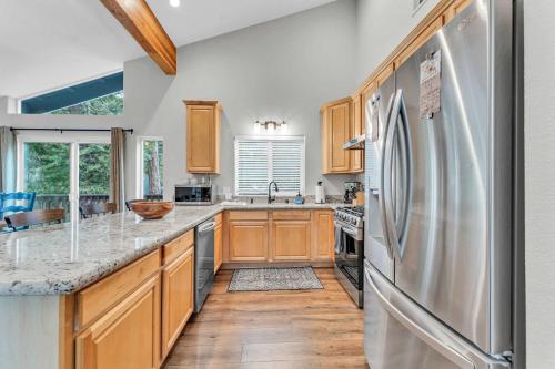 una cucina con mobili in legno e un frigorifero in acciaio inossidabile di Tahoma Family Getaway with Bocce Ball & BBQ Grill a Tahoma