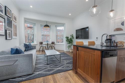 a kitchen and living room with a couch and a table at 304 Newbury Street by Thatch in Boston