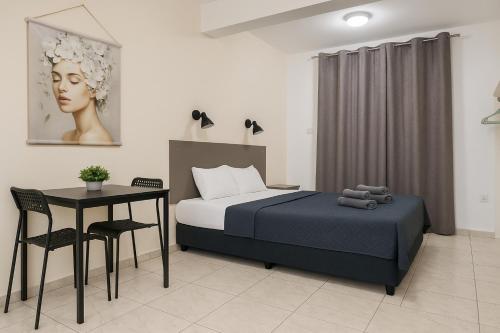 a bedroom with a bed and a table and chair at Summer's Hotel Apartments in Ayia Napa