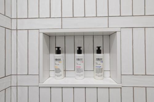 a shelf with four bottles ofodorizers on a wall at 304 Newbury Street by Thatch in Boston