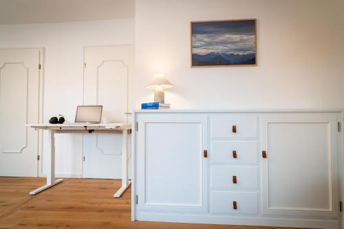 an office with a desk and a table with a laptop at M8 Apartment - Zentral und exklusiv auf 290 m2 in Sonthofen