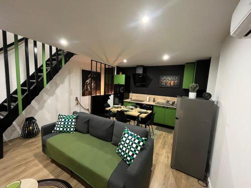 un salon avec un canapé vert et une cuisine dans l'établissement Escapade 6 pers 2 sdb 2wc terrasse parking privée, à Moulins-lès-Metz